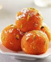 Homemade motichur laddu with ghee and saffron, placed on a traditional brass plate